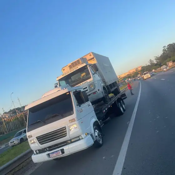 Caminhão refrigerado sendo removido em rodovia no fim da tarde