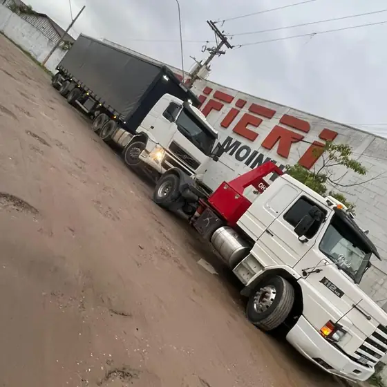 Carreta sendo rebocada em terreno irregular de terra